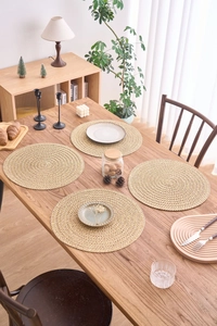 Nahaufnahme kreisförmiger gewebter Platzsets mit Spiralstruktur auf einem Holztisch