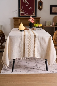 Detail of bohemian cotton linen tablecloth with fringe tassels and hollow embroidery texture