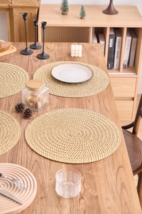 Detail eines runden Tischsets mit rustikaler Spiraltextur und natürlicher Strohoptik
