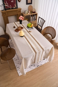 Detail of bohemian linen tablecloth with geometric embroidery and fine tassel edges