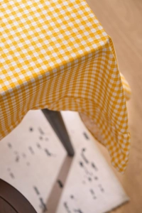 Détail de la nappe vintage française à carreaux jaunes avec texture coton et bordure froufrou