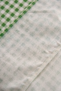 Gros plan sur le tissu en coton et lin à carreaux verts avec des détails de volants froncés