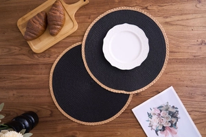 Detail showing two-tone woven placemats with black fibers and natural straw fringe