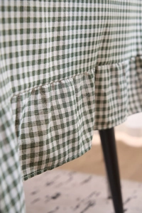 Détail de la nappe à carreaux verts avec des bords à volants et une texture de tissu naturelle