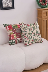 Detail of Christmas jacquard cushion covers with elk and holly patterns on a cozy sofa