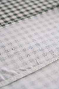 Vue macro du tissu vichy vert foncé avec des coutures fines pour les nappes