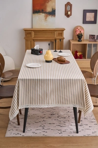 Close-up of brown and white striped tablecloth with delicate white lace edge detailing