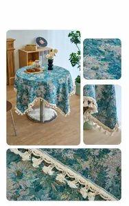 Detail of blue oil painting floral tablecloth with white curved fringe on thick woven fabric