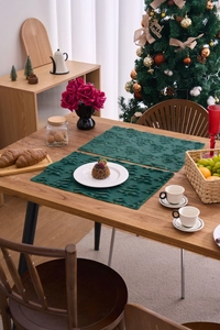 Detail of dark green knitted Christmas placemats with 3D tree pattern and gold dots