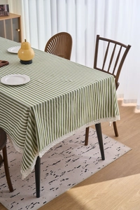 Close-up of green and white striped tablecloth with delicate white lace edge trim