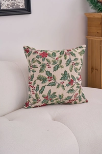 Detail of Christmas jacquard cushion with holly leaf and red berry pattern on sofa