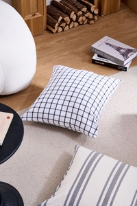 Close-up of geometric black and white plaid cushion cover in a minimalist home setting