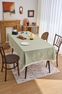 Detailed close-up of green and white striped tablecloth with elegant white lace border edges