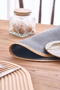 Detail of grey woven placemat showing flexible fiber texture and natural grass edge