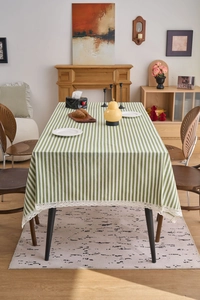 Close-up of green and white striped tablecloth with vintage lace edge trim for dining decor