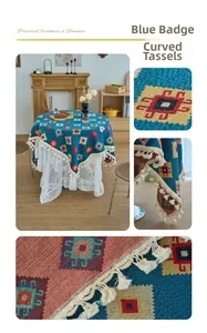 Detail of blue badge pattern jacquard tablecloth with curved tassels and lace layer