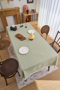Detail of green striped rectangular tablecloth with elegant white lace border trim