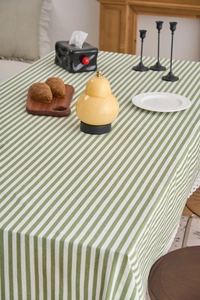 Detailed close-up of green striped tablecloth with elegant white lace borders