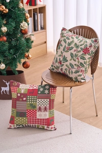 Close-up of rustic Christmas cushion covers featuring holly leaves and holiday patchwork