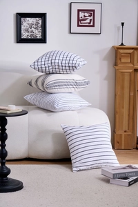 Close-up of four geometric pillow covers in black and white minimalist patterns