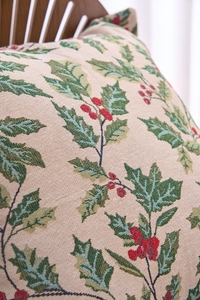 Close-up of jacquard woven pillowcase featuring holly leaves and red berries pattern