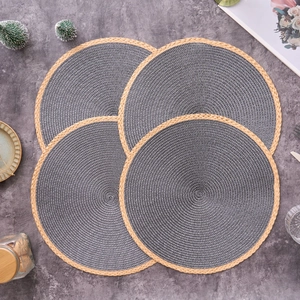 Close-up of four round woven placemats with grey body and light brown fringe edges