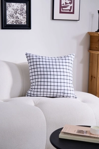 Detail of square cushion cover with black and white checkered pattern on a sofa