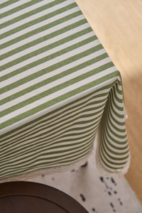 Close-up of green striped cotton tablecloth with delicate white lace edge detailing