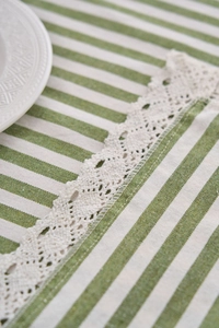 Close-up of green and white striped cotton tablecloth with delicate white lace edges