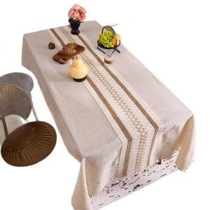 Minimalist beige linen tablecloth with bohemian brown woven runner and fringe tassels
