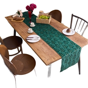 Dark green Christmas table runner with 3D embossed tree pattern on a wooden dining table