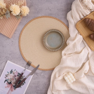Modern round woven placemat with tassels, rustic beige straw texture for dining decor
