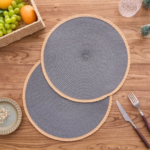 Modern minimalist round woven placemat set with tassel decor on a natural wooden tabletop
