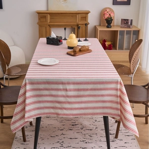 Modern red and white horizontal striped linen tablecloth on a wooden dining table