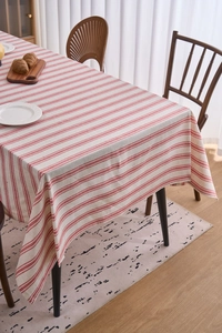 Close-up of beige cotton linen tablecloth with red stripes and neat edge stitching