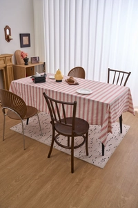 Detailed close-up of red and white striped linen tablecloth with natural drape on a table