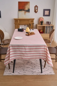 Detailed texture of red and white striped cotton linen tablecloth on a rectangle dining table