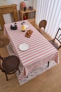 Close-up of red and white striped linen tablecloth with natural drape and woven texture