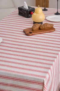 Detailed texture of red and white striped linen tablecloth with rustic wood decor