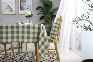 Primer plano de mantel a cuadros verde y blanco y cojín a juego en un comedor moderno