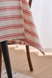 Close-up of red and beige striped cotton linen tablecloth showing texture and hem