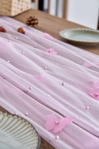 Detailed view of pink lace table runner with 3D butterfly appliques and pearl embroidery