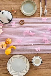 Close-up of pink lace table runner with embroidered butterfly appliques and pearls