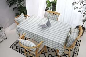 Detalle del mantel de lino a cuadros azules y blancos con cojines de silla a juego