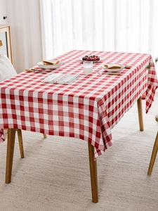 Detalle del mantel de cuadros rojos y blancos con textura sobre una mesa de madera