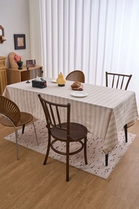 Close-up of beige cotton linen tablecloth featuring a striped pattern and woven texture