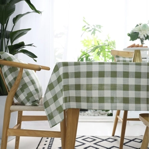 Mantel a cuadros verde y blanco con fundas de cojín a juego en un entorno doméstico luminoso