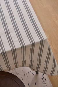 Close-up of linen blend tablecloth showing grey striped texture and natural fabric drape