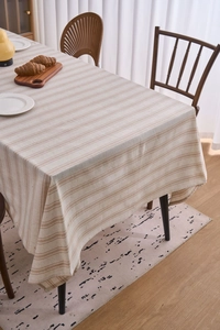 Close-up of rectangular linen tablecloth with horizontal beige and white stripes