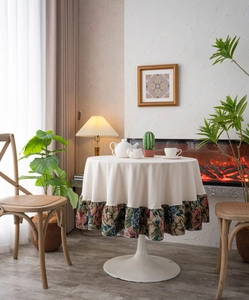 Close-up of cream round tablecloth with floral jacquard ruffle edge in home setting